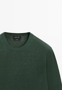 Grüner Rundhalspullover aus 100 % Leinen mit geripptem Kragen und Massimo Dutti Markenetikett im Nackenbereich.