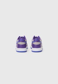 Purpursarkani Nike sporta apavi ar gludu ādas augšdaļu, kontrastējošām beigu akcentiem un baltu starppaliktni ar purpursarkanu gumijas zoli.