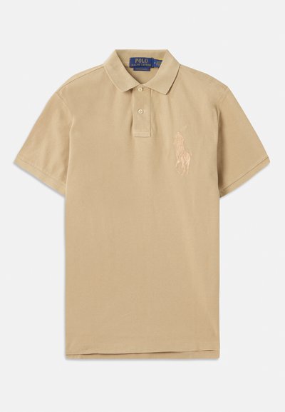 Bēša polo krekls ar klasisku apkakli, divām pogām un izšūtu logo kreisajā krūtī, izgatavots no mīkstas kokvilnas auduma.