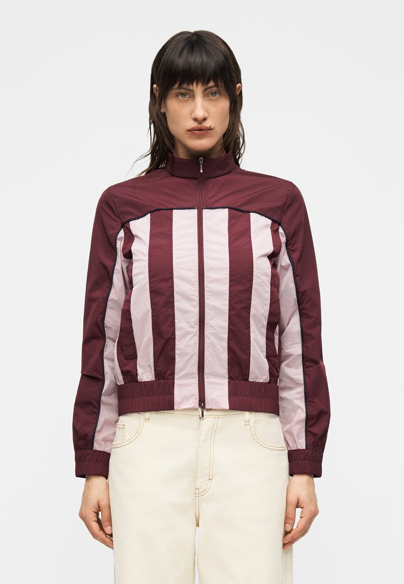 Vinrød og pinkstribet jakke med høj krave og lynlåslukning; elastiske manchetter og linning; letvægts, glat stoffetextur.