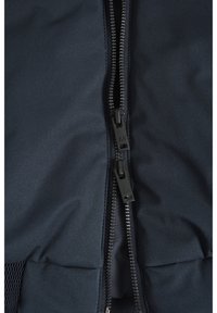 Giacca navy con zip bidirezionale, tessuto liscio e sezioni imbottite all'orlo inferiore con dettaglio in rete.
