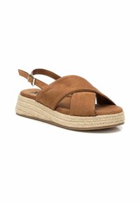Sandalias de cuña de ante marrón con suela de yute tipo espadrille. Diseño de punta abierta y correa ajustable en el tobillo. Textura suave y detalle de tiras cruzadas.