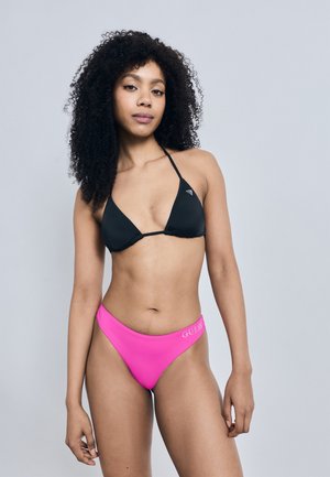 Top triunghiular de bikini negru cu bretele subțiri; chiloți de bikini roz cu talie înaltă, având inscripția "GUESS" în alb. Textură netedă, design minimalist.
