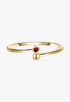 Gold ring with a thin band, featuring a red gemstone and a round gold accent. Smooth texture, minimalist design.