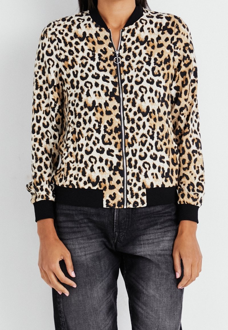 Chaqueta bomber de estampado de leopardo con cremallera frontal, puños y dobladillo acanalados en negro, confeccionada en tela suave, con tonos marrones y crema.