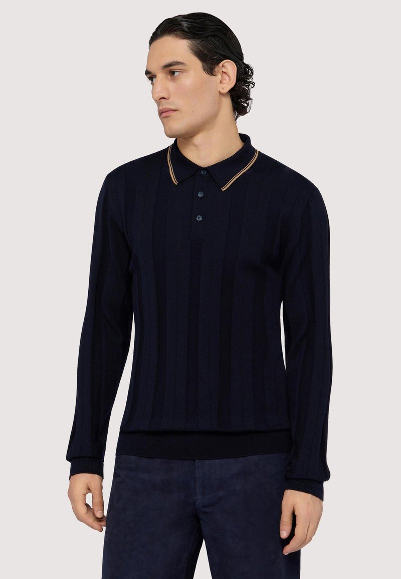 Námořnická modrá polo košile s dlouhým rukávem, vertikálně ribbovanou texturou, tříknoflíkovou légou a kontrastními béžovými akcenty na límci.