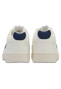 Weiße Ledersneaker mit glatter Textur und navy blauen Akzenten an der Ferse, im Low-Top-Design mit beiger Gummisohle.