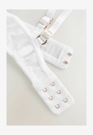 Biely podprsenka z oka a látky s nastaviteľnými ramienkami a ružovo-zlatým kovaním. Má zapínanie na háčiky a očká so štyrmi háčikmi.