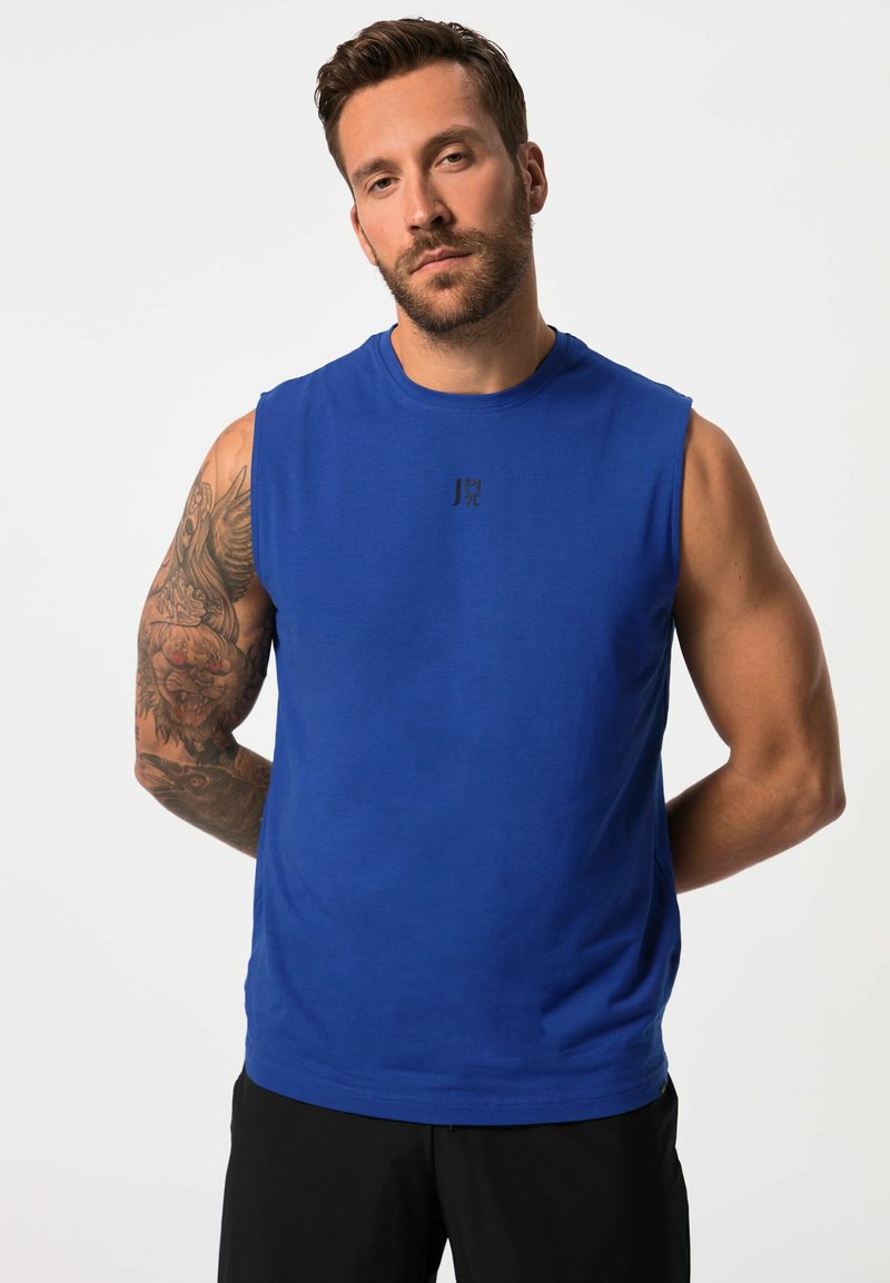 Blauwe mouwloze shirt van een gladde stof. Heeft een ronde halslijn en een klein zwart logo op de borst. Geen patronen of versieringen.