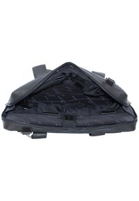 Zwarte leren tas met een ritssluiting, voorzien van een ruime binnenkant gevoerd met patroonstof en meerdere vakken voor organisatie.