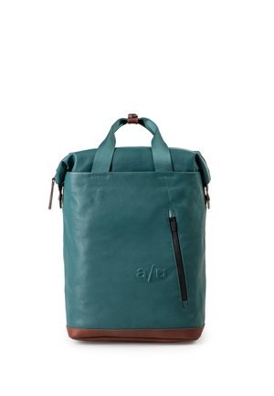 Grüner Leder-Rucksack mit braunem Boden, zwei Griffen, einer vertikalen Reißverschlusstasche und geprägtem "a/u" Logo auf der Vorderseite.