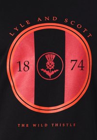 Juodas marškinėlių su centriniu apvaliu grafiniu vaizdu, kuriame raudonos ir rožinės juostos, tekstai "LYLE AND SCOTT" ir "THE WILD THISTLE", bei šlaito dizainas.