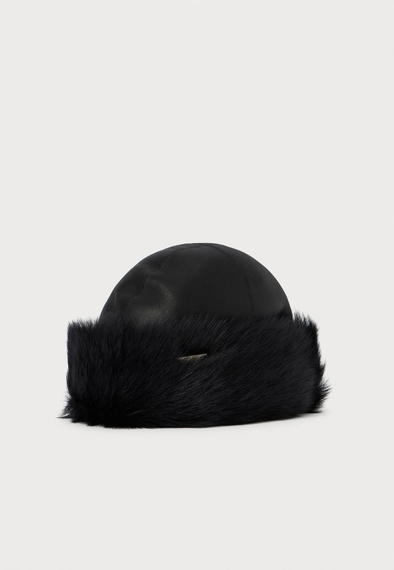 Black leather winter hat with wide black faux fur trim and small metallic logo detail on front.