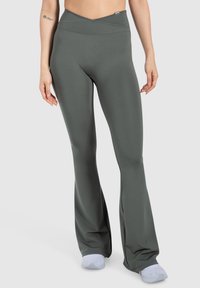 Leggings grigi a zampa d'elefante realizzati in tessuto liscio e elasticizzato, con vita alta e design incrociato nella parte superiore, che presentano una vestibilità attillata sulle gambe.