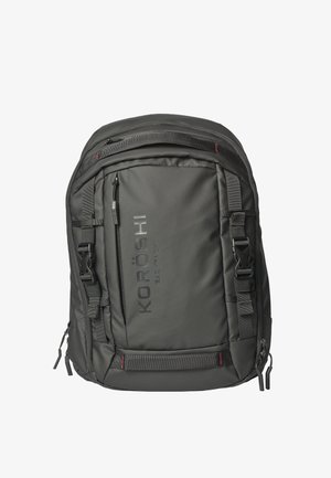 Mochila negra KORÖSHI con múltiples compartimentos con cremallera, correas ajustables y hebillas sobre fondo blanco.
