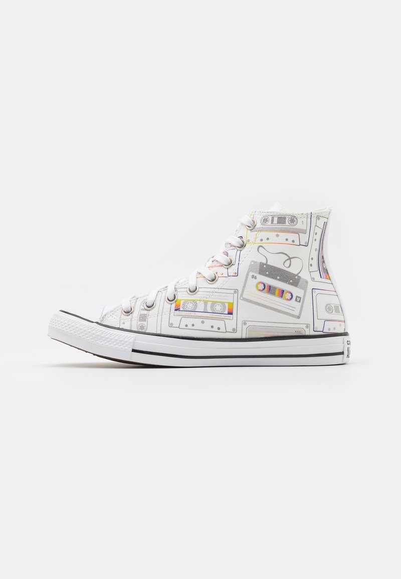 Baskets montantes blanches avec motifs colorés de cassettes rétro, lacets blancs et semelle blanche avec des bandes noires sur fond uni.