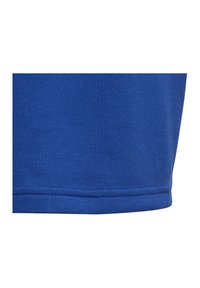 Blaues strukturiertes Gewebe mit einem gestrickten Muster und kontrastierendem einfarbigen Saum. Das Material wirkt glatt und leicht dehnbar.