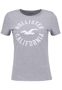Szara i biała koszulka z krótkim rękawem, wykonana z bawełny. Posiada wyraźne białe logo Hollister California na środku. Design z okrągłym dekoltem.