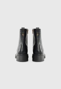 Black leather ankle boots with a smooth texture, featuring zip closures, a textured sole, and a round toe. Back loops for easy wear.