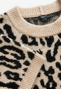 Beżowy sweter w czarne lamparty. Wzór dzianiny, ribbowe wykończenia przy dekolcie i mankietach. Metka wewnątrz kołnierza z logo marki "NEXT".