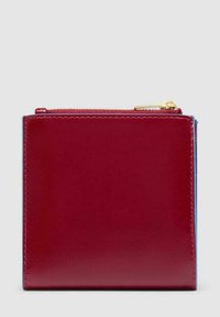 Vierkante bordeauxlederen portemonnee met zichtbare stiksels en een goudkleurige rits op de bovenkant, tegen een lichtgrijze achtergrond.