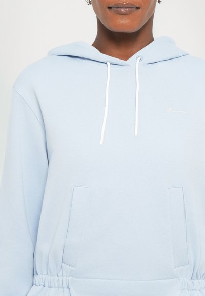 Light blue hooded sweatshirt made of soft fabric, featuring a front pocket, drawstring hood, and a small embroidered logo on the chest.