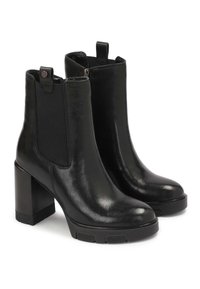 Botine negre din piele, cu o suprafață lucioasă, panouri laterale elastice și un toc pătrat chunky. Dispune de mânere pentru a fi ușor de încălțat.