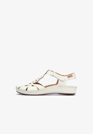 Sandale en cuir blanc avec un design découpé, une bride de cheville et une couture le long du bord. La semelle plate offre un profil décontracté.