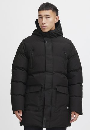 Abrigo de plumas negro con cierre frontal, capucha extragrande, dos bolsillos frontales y bolsillos con cremallera en el pecho. Fabricado con material liso e insulated.