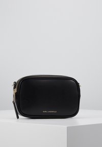 Borsa a tracolla rettangolare nera realizzata in pelle liscia con cerniera dorata e logo del marchio impressa sul fronte.