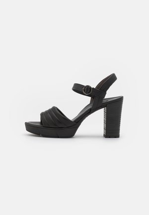 Sandale à talons hauts en cuir noir avec bride avant rembourrée, bride de cheville avec boucle, talon bloc épais et semelle plateforme.