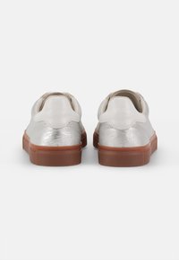 Men’s sneakers with a metallic silver leather upper, contrasting brown rubber sole, rounded toe, and padded collar.