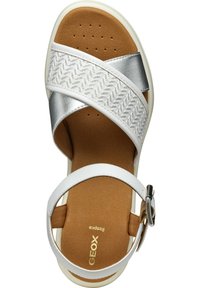 Sandal bianco con accenti argentati, fascia testurizzata, soletta marrone imbottita e cinturino regolabile alla caviglia. Presenta un design a motivo.