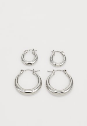 Strieborné kruhové náušnice, ktoré sú k dispozícii v dvoch veľkostiach. Hladký povrch, zaoblený dizajn a lesklý finiš s bezpečným závěsným uzáverom.