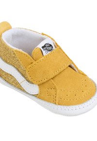 Sneaker in camoscio giallo con accenti bianchi, caratterizzata da un design glitterato, cinturino in Velcro e punta arrotondata. Etichetta del marchio visibile sulla linguetta.