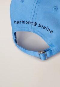 Svetlomodrá čiapka z látky s vyšitým logom "harmont & blaine" v čiernej farbe, so striebornou nastaviteľnou prackou na zadnej strane.
