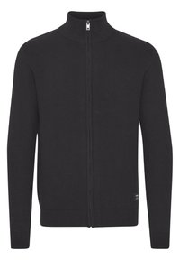 Svart zip-up cardigan i stickad tyg. Har hög krage, ribbad nederkant och muddar, samt en liten märkeslapp på den nedre sidan.