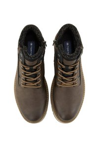 Botas de cuero marrón hasta el tobillo con un forro de piel sintética, que cuentan con cordones beige, ojales metálicos y un cierre de cremallera en el lateral.