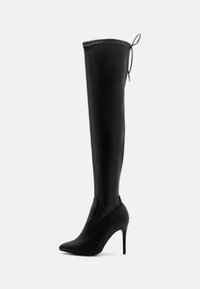 Botas negras hasta el muslo con un diseño ajustado y elegante, puntera afilada, tacón alto de aguja y un detalle de cordones en la parte superior con un acabado mate suave.