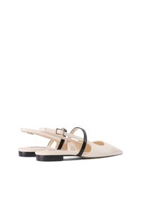 Scarpe slingback in pelle beige con punta appuntita, dotate di un cinturino nero e un tacco basso a blocco. L'interno è leggermente testurizzato.