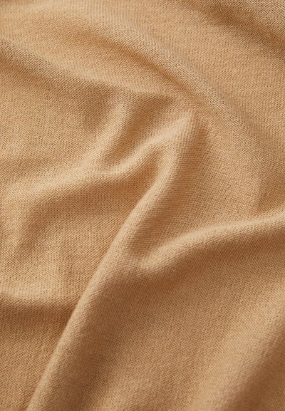 Light brown fabric with a soft, textured surface, featuring fine knit patterns and slight ripples, indicating drape and flexibility.