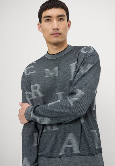 Maglione grigio con texture a righe e grandi lettere stampate in una tonalità più chiara. Presenta un collo rotondo e maniche lunghe.