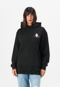 Black hoodie made of cotton blend, featuring a front pocket and a colorful graphic on the chest. The design emphasizes comfort and casual style.