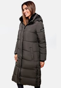 Long puffer coat in dark gray with a faux fur-lined hood, quilted design, front zipper, and two side pockets. Accented with a logo patch.