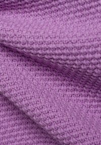 Lila strukturiertes Gewebe mit einem gewebten Muster, das eine weiche, taktile Oberfläche aufweist. Falten erzeugen Tiefe und visuelles Interesse.