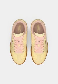 Yellow and cream sneakers with light pink laces, featuring a smooth leather upper, round toe, and a gum rubber sole.