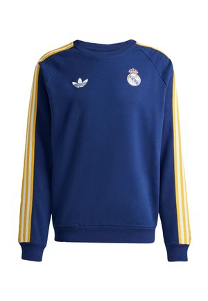 Sweatshirt bleu à manches longues et col rond avec des rayures jaunes et blanches sur les manches, logo Adidas sur le côté gauche de la poitrine et écusson du Real Madrid sur le côté droit.