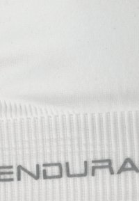 Hvid sportsstrømpe med ribbet tekstur og grå 'ENDURA' branding. Stoffet ser blødt og strækbart ud, designet til komfort og ydeevne.
