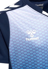 Marinblå skjorte med gradientdesign, der har et lys blå geometrisk mønster. Brandlogoet "hummel" er præsenteret fremtrædende i hvidt.