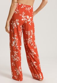 Rode bloemenbroek met witte bladerenpatronen, met een wijd uitlopende pasvorm en een elastische tailleband voor comfortabel dragen en een relaxte fit.